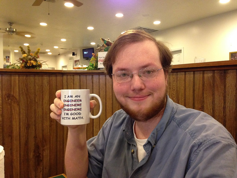 Sam Reed holds a congratulatory coffee mug after officially becoming an engineer